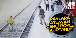 Hindistan'da polis raylara atlayan genci son anda kurtardı